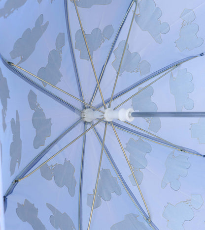 Underside of blue umbrella showing metal ribs and pale construction truck silhouettes