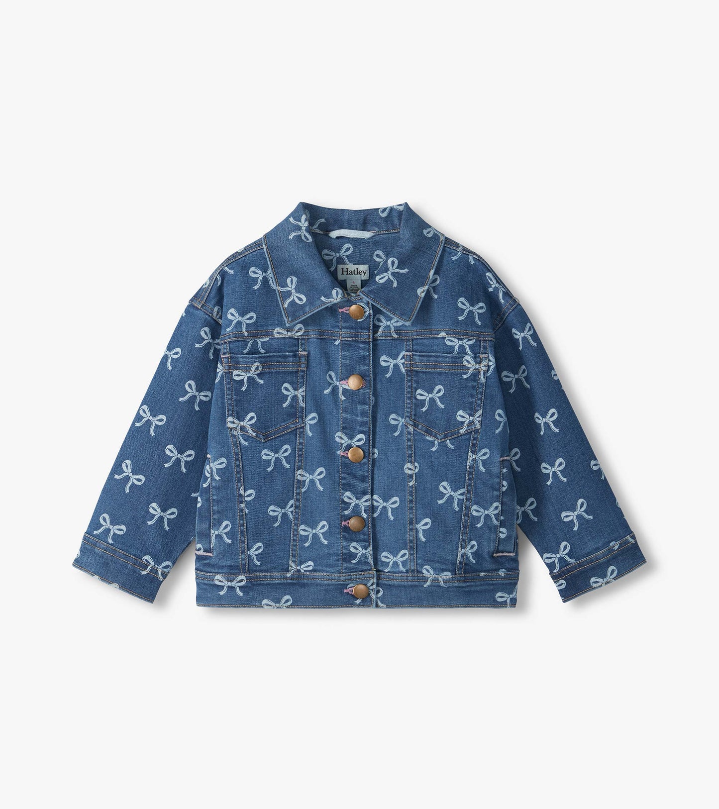 Front view of blue slouchy denim jacket with allover bow print, button front, and chest pockets