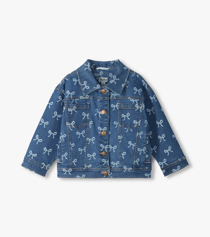 Front view of blue slouchy denim jacket with allover bow print, button front, and chest pockets