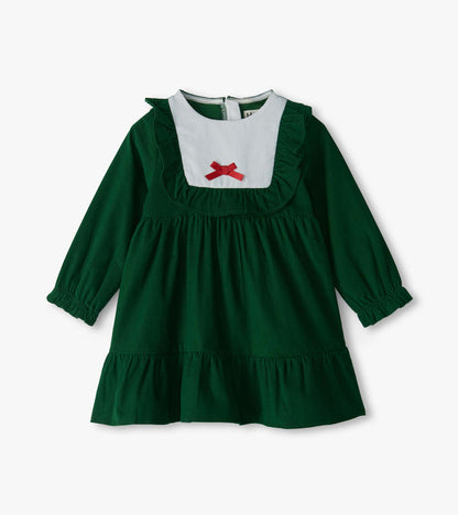 Front view of green long sleeve ruffle dress with white bib yoke, red bow, and tiered skirt