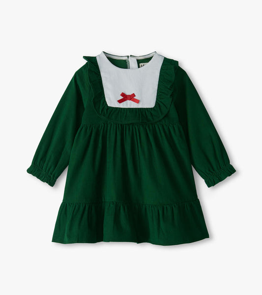 Front view of green long sleeve ruffle dress with white bib yoke, red bow, and tiered skirt