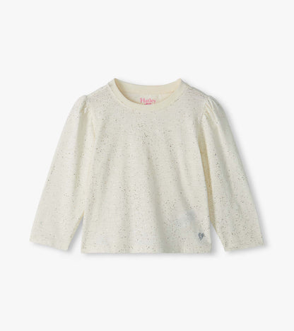 Front view of cream infant tee with silver speckles, puff shoulders, long sleeves, and small heart at hem