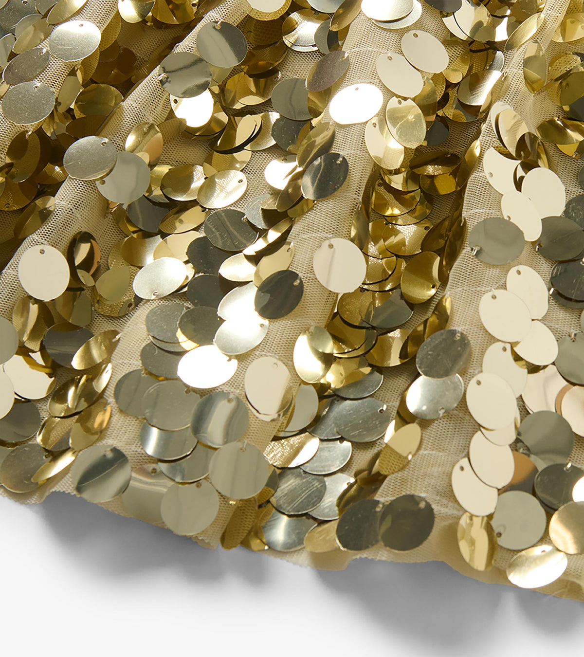 Close-up of large round gold sequins on the girls skirt