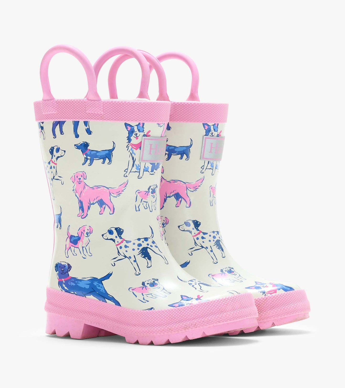 Pair of cream kids rain boots with pink handles and trim, covered in pink and blue dog illustrations