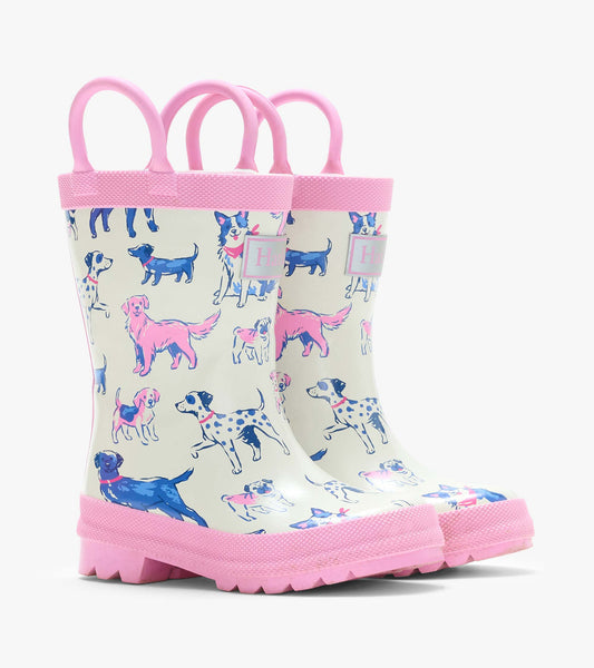 Pair of cream kids rain boots with pink handles and trim, covered in pink and blue dog illustrations