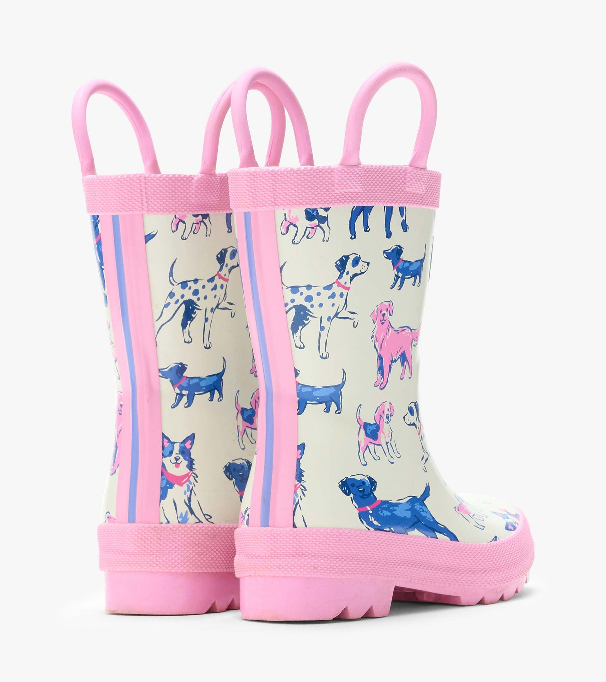 Back angled view of cream rain boots with pink handles, side stripes, and pink and blue dog print