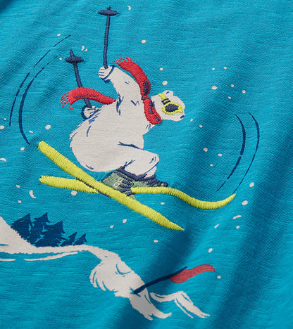 Close-up of embroidered skiing bear graphic with red scarf and yellow skis