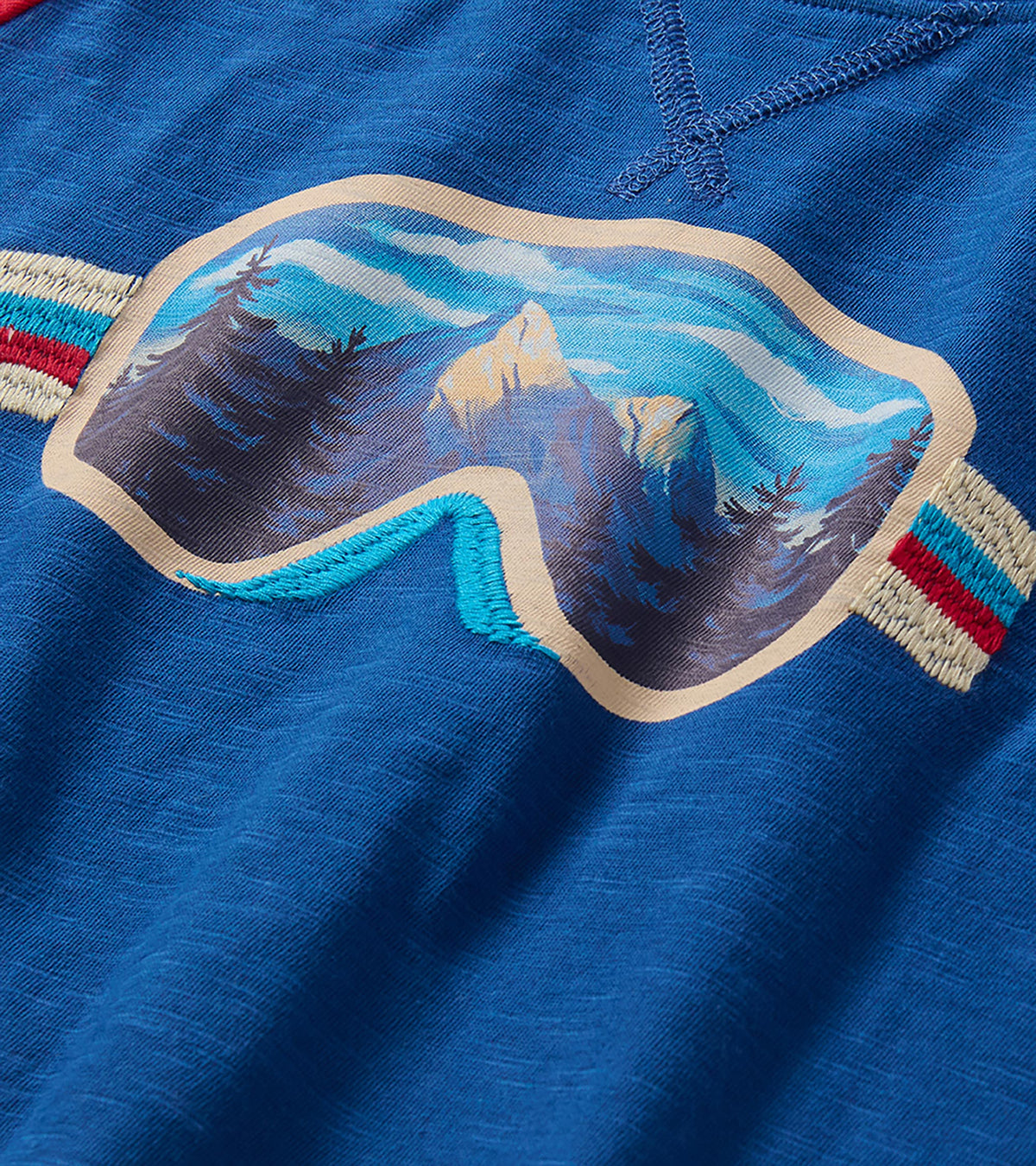 Close-up of ski goggles graphic with mountain landscape and striped side details on blue shirt