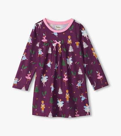 Front of girls purple nightdress with pink neckline, bow, and Nutcracker print of ballerinas, mice, trees and holly