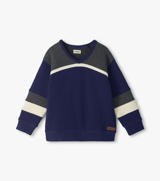 Front view of kids blue pullover top with dark gray yoke, curved cream stripe, and striped long sleeves