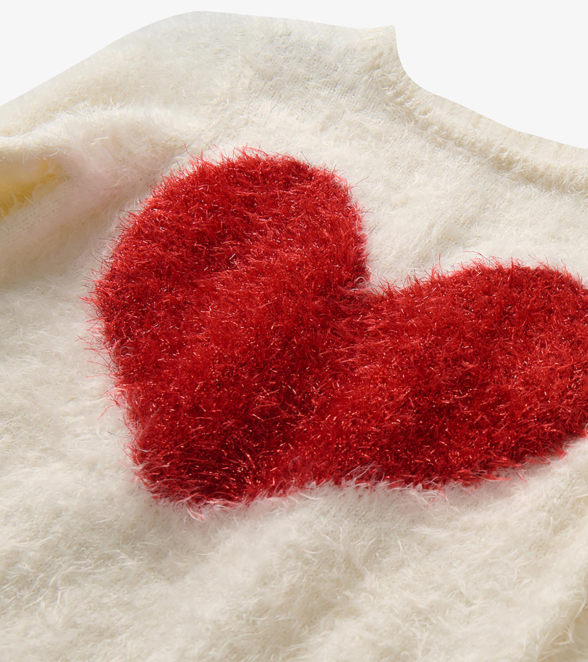 Close-up of the red heart graphic on the cream fuzzy sweater