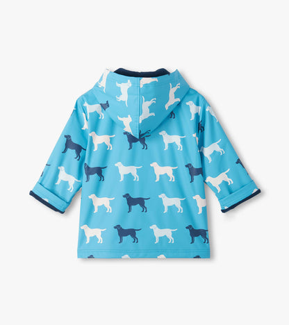 Back view of blue hooded rain coat with white and navy dog print and folded cuffs