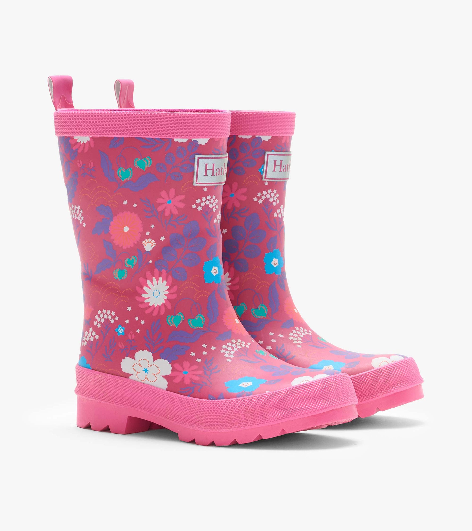 Pair of pink kids rain boots with multicolor tiny floral print, front angled view and pull tabs