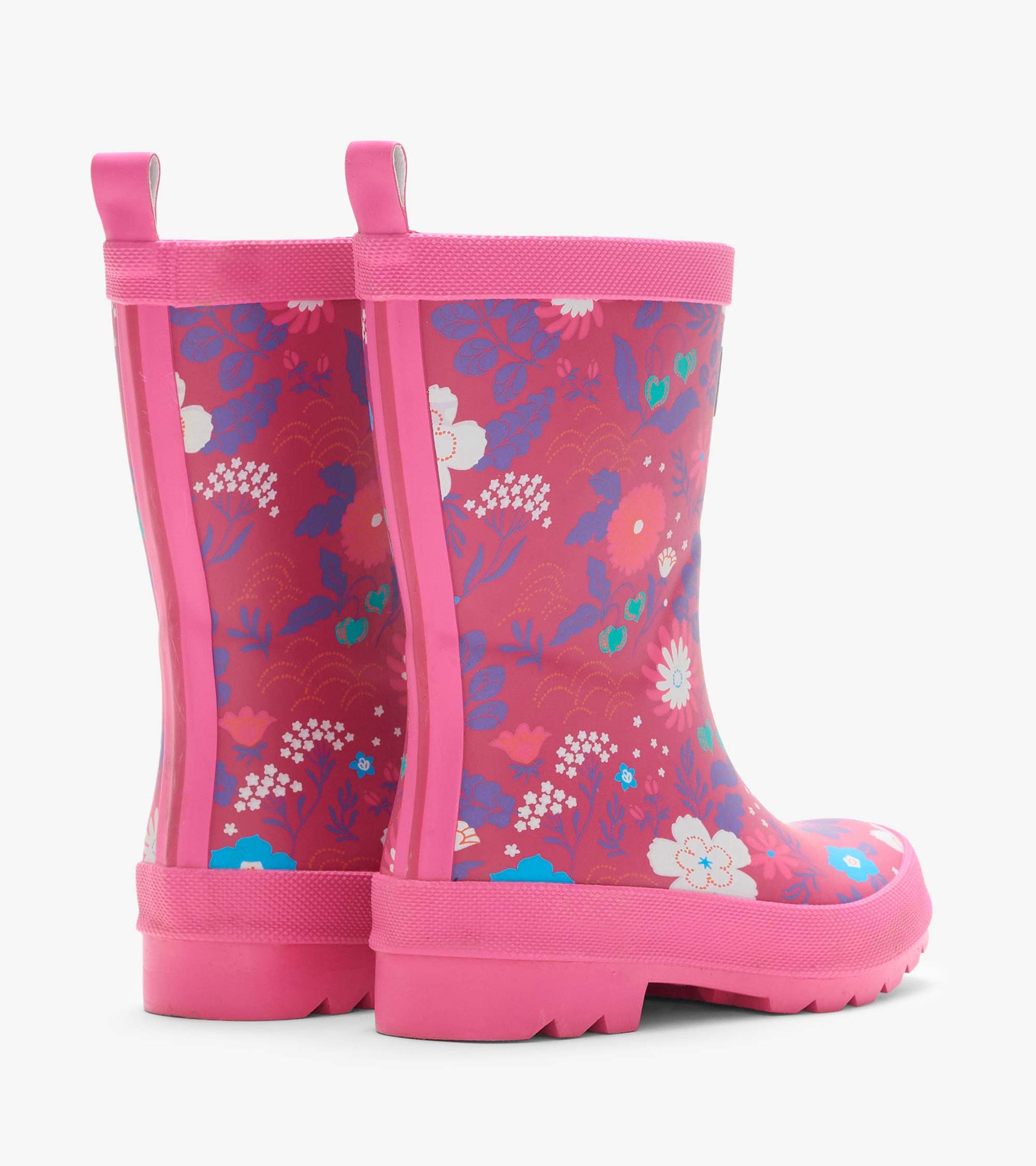 Rear angled view of pink kids rain boots with tiny floral print, back seams, and pull tabs