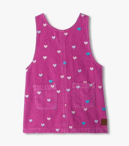 Front of pink pinafore dress with embroidered hearts, scoop neck, two front pockets, and center seam