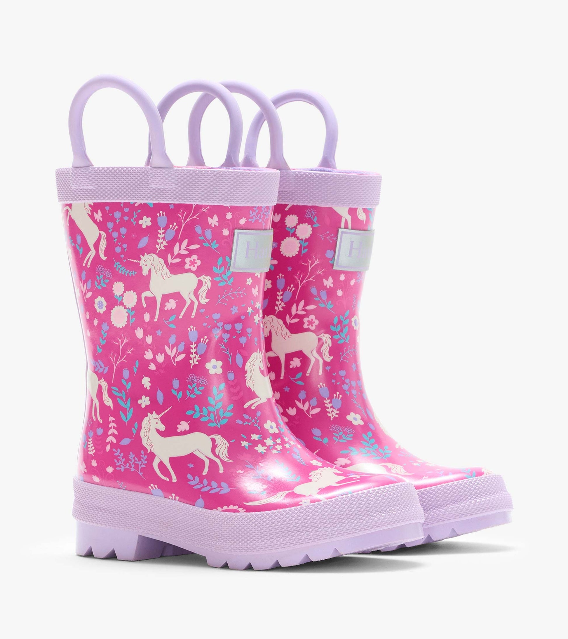 Pair of pink kids rain boots with lilac handles and soles, covered in unicorn and floral print