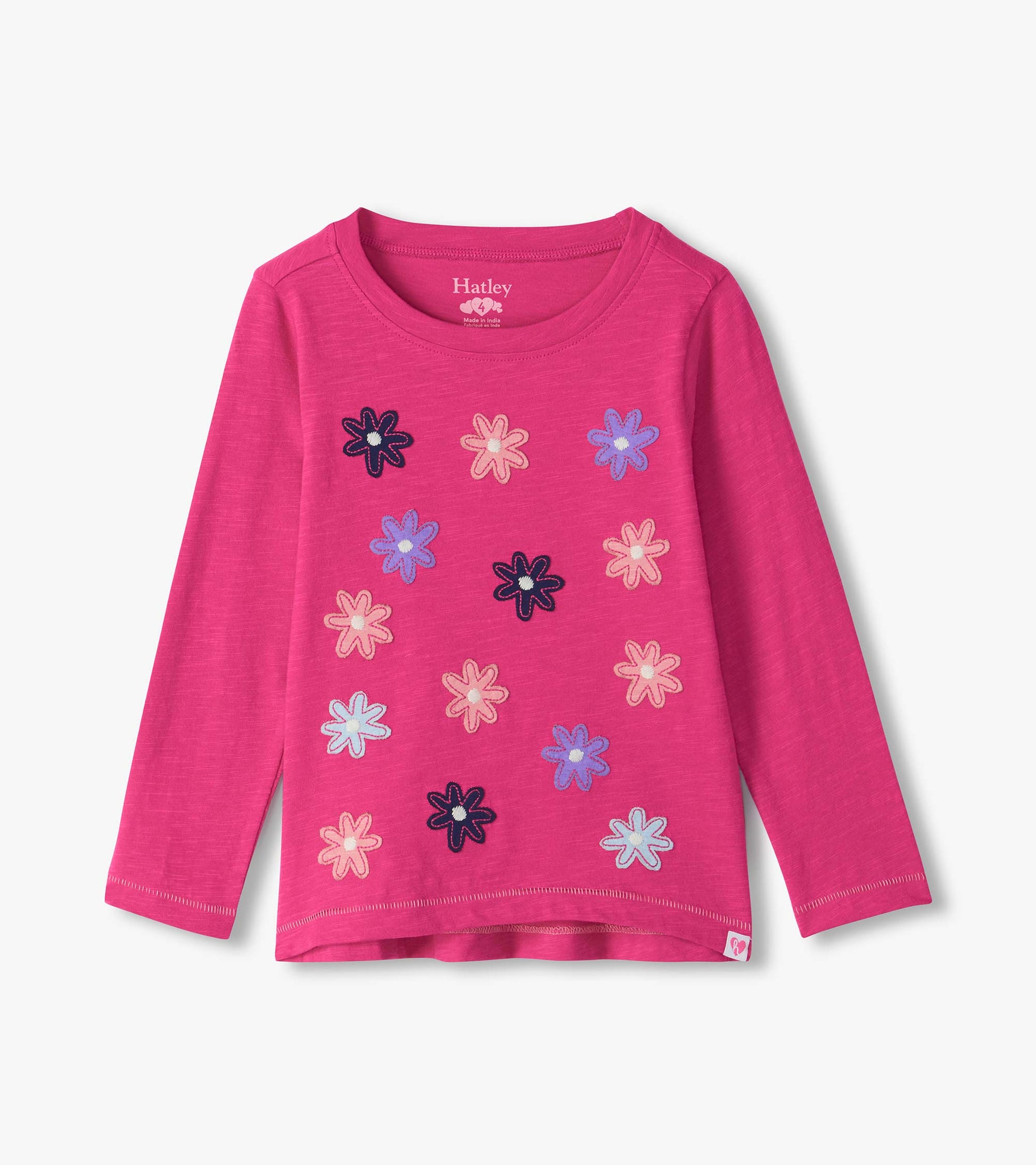 Bright pink long sleeve tee with scattered flower graphics in pink, purple, navy, and light blue