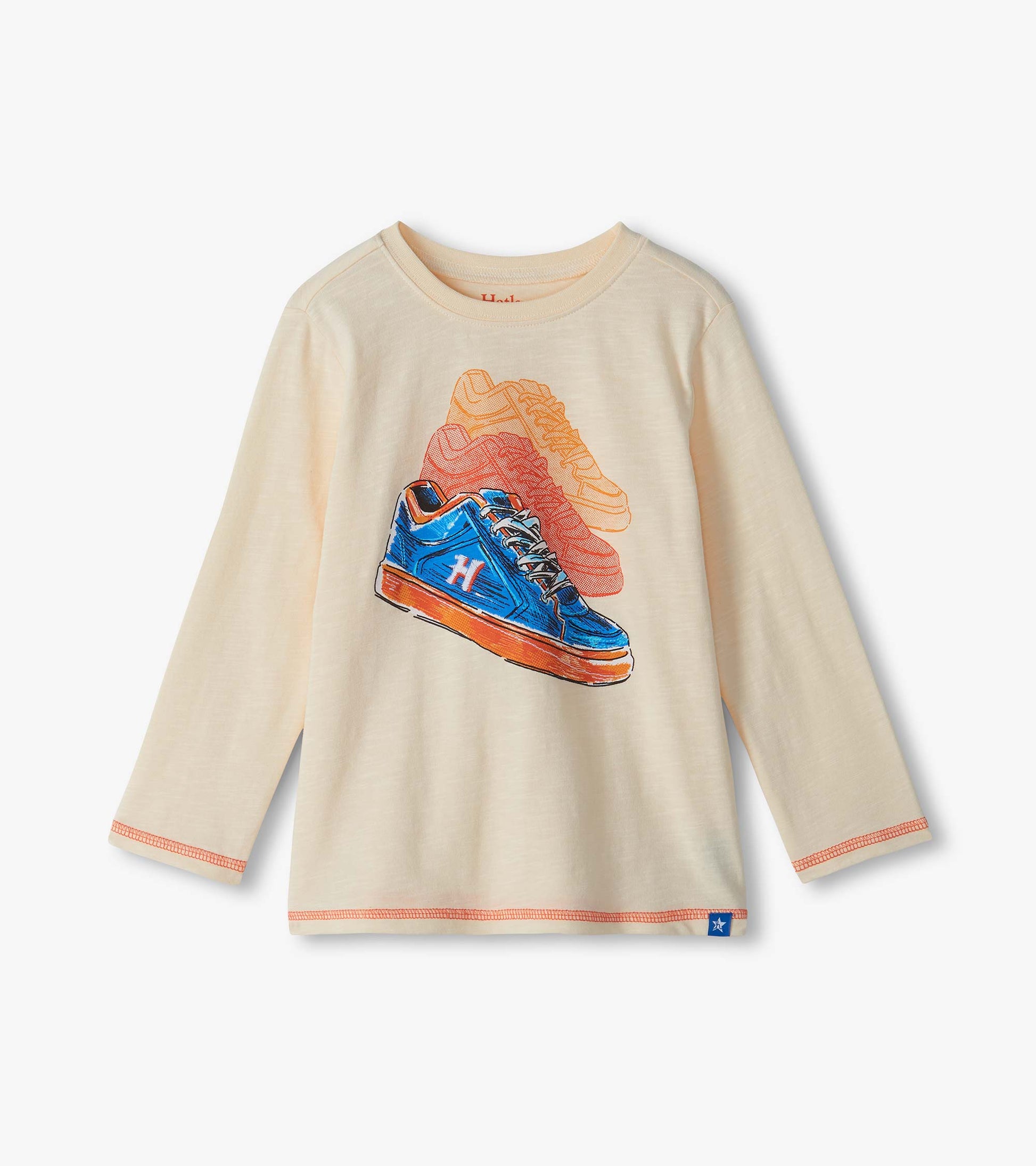Cream long-sleeve crew neck tee with colorful sneaker graphic on the front and contrast stitching at cuffs and hem