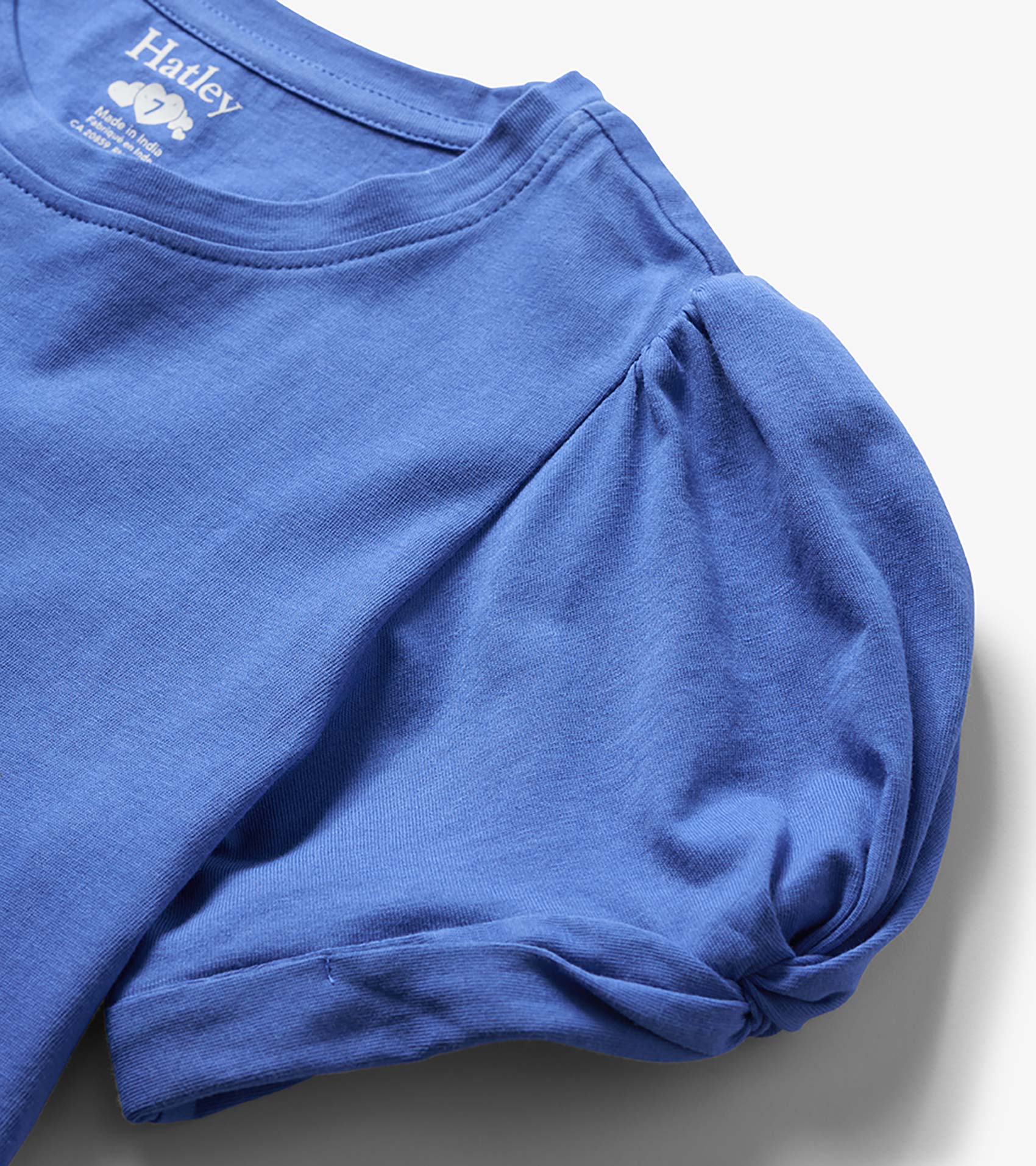 Blue girls' long-sleeve T-shirt with twisted sleeve detail, folded close-up view