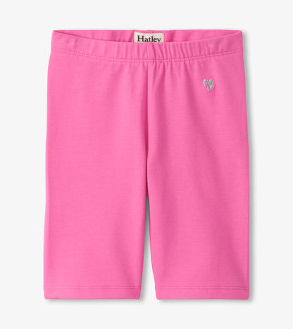 Pink girls bike shorts with elastic waistband and small heart graphic, front view