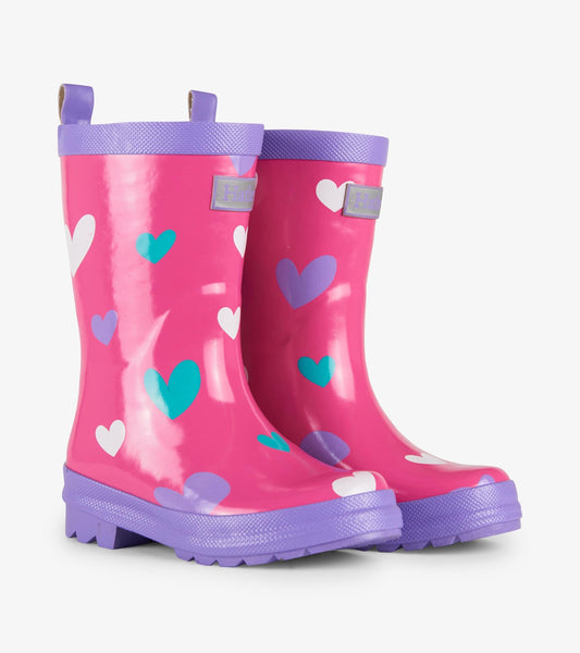 Pink waterproof wellies with colorful heart patterns and purple soles, designed for kids.