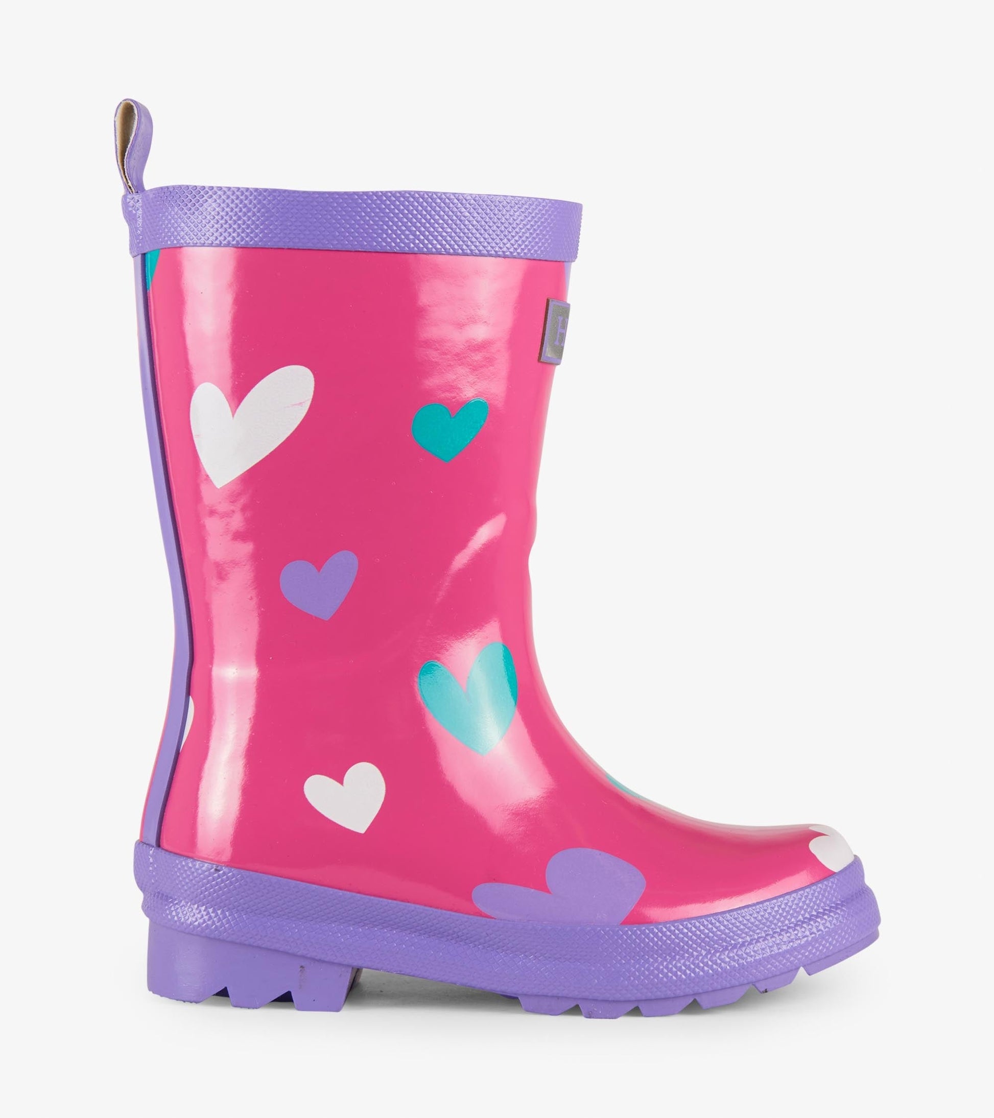 Pink waterproof wellies with colorful heart patterns and a purple sole, designed for kids. Side view.