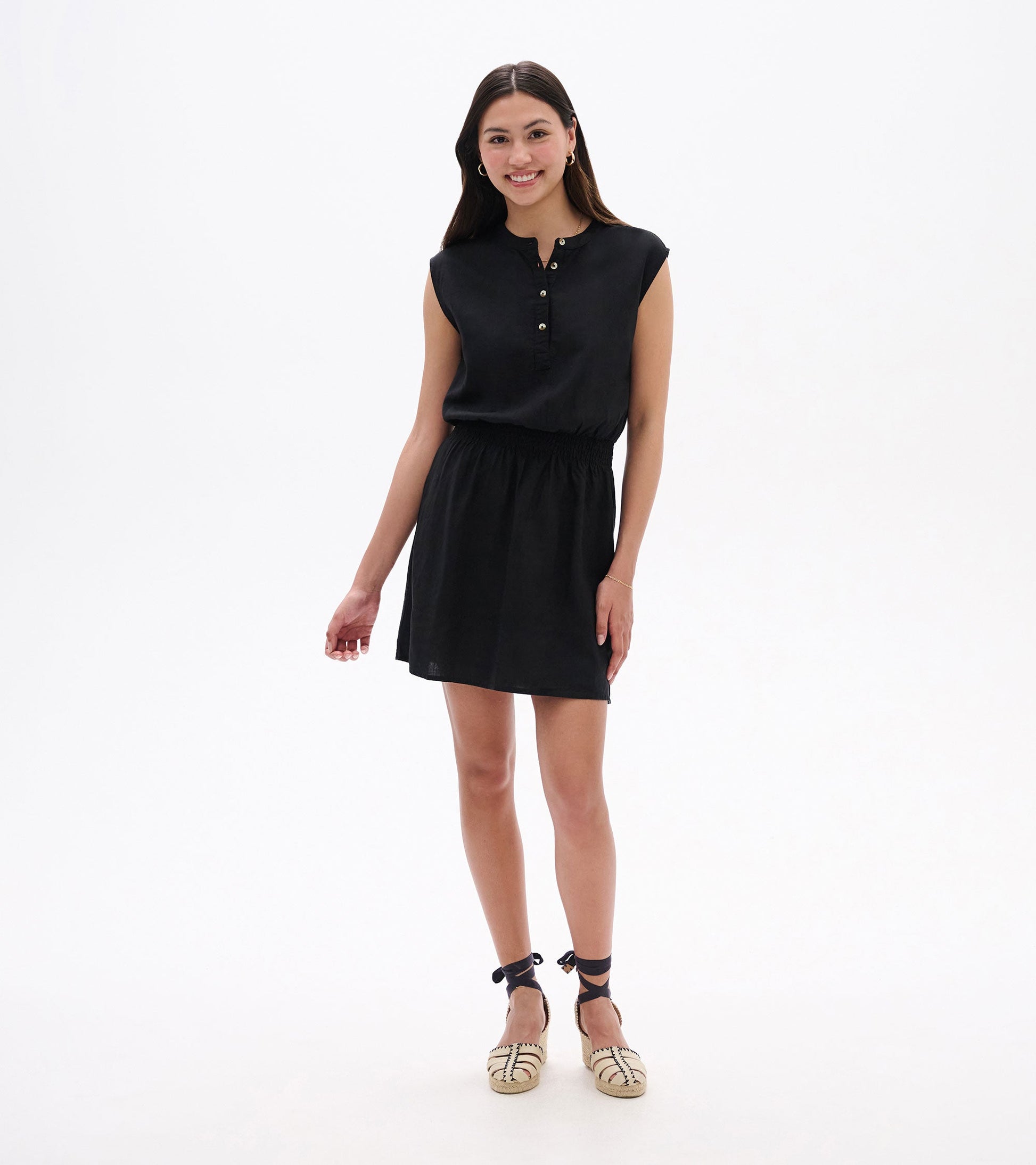 Black sleeveless dress with a buttoned neckline and elastic waist, styled for a casual look.