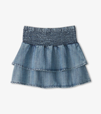 Blue denim girls skirt with smocked waistband and tiered ruffle layers, front view