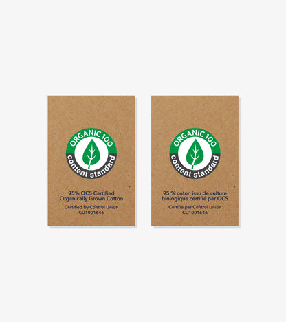 Two organic cotton certification labels on brown cardboard background, one in English and one in French