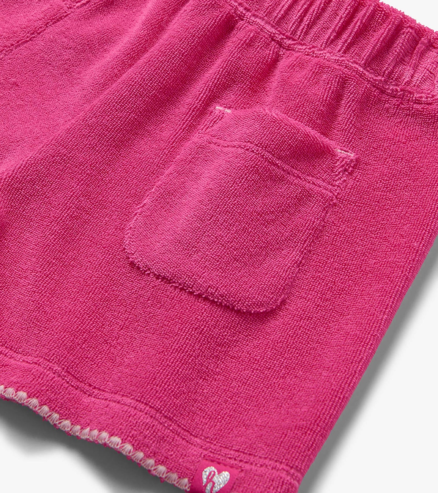 Pink textured knit shorts with elastic waistband and back pocket, close-up view