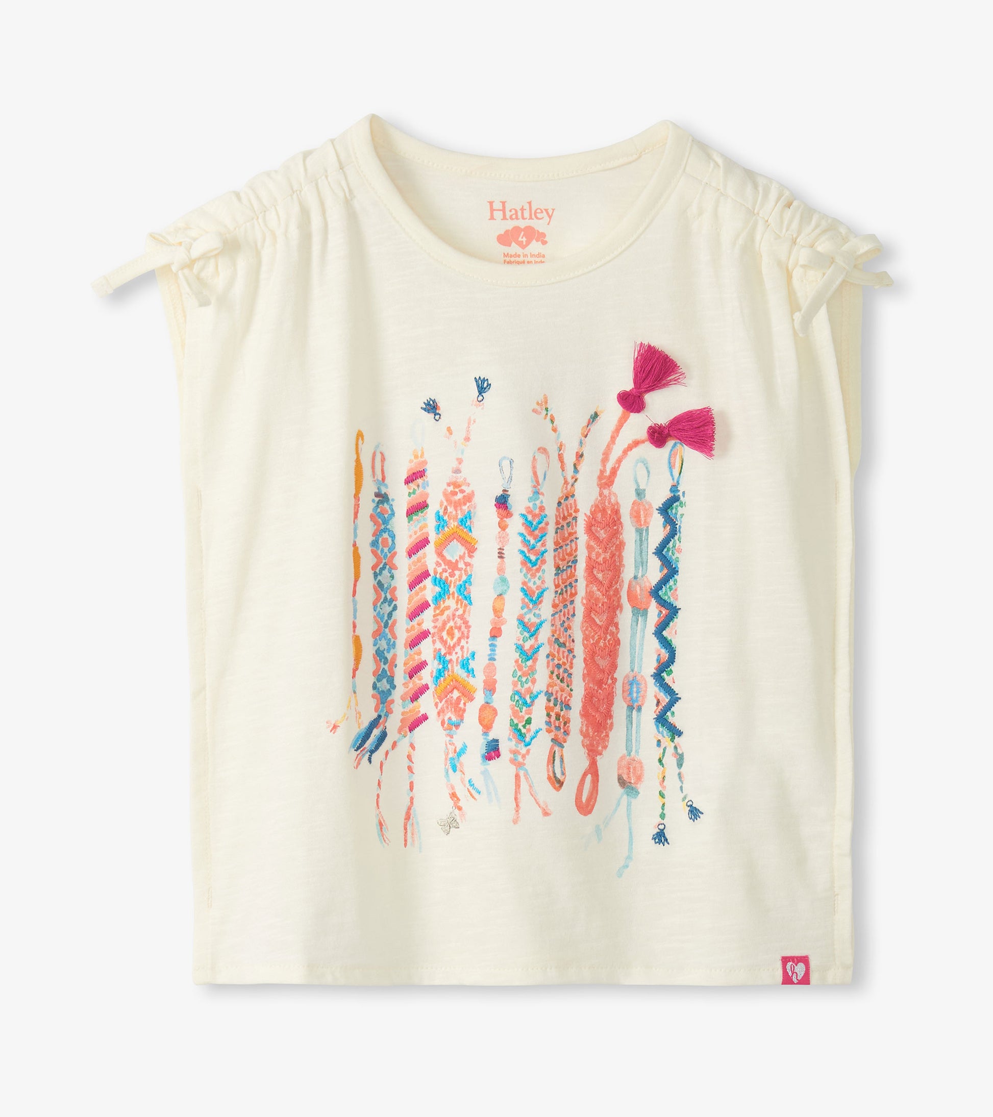Cream girls top with cinched shoulders and colorful friendship bracelet graphic, front view