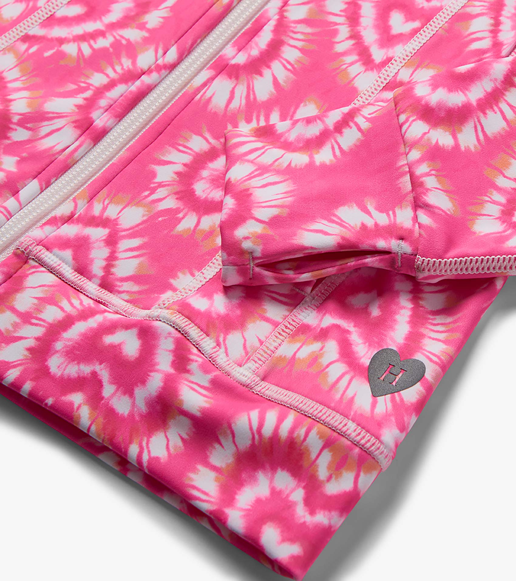 Pink and white tie-dye girls active jacket with zipper, pocket, and heart logo detail, close-up view