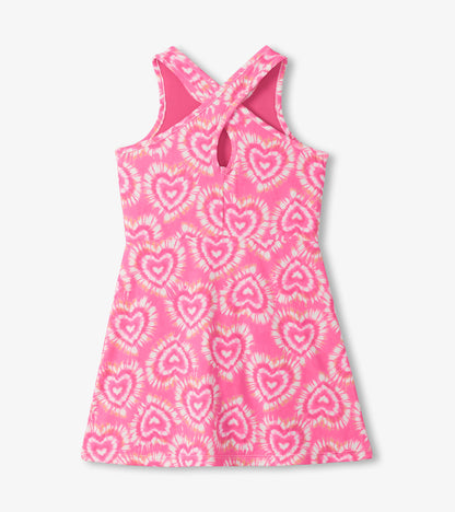 Pink sleeveless A-line dress with heart tie-dye print and crisscross back straps, front view