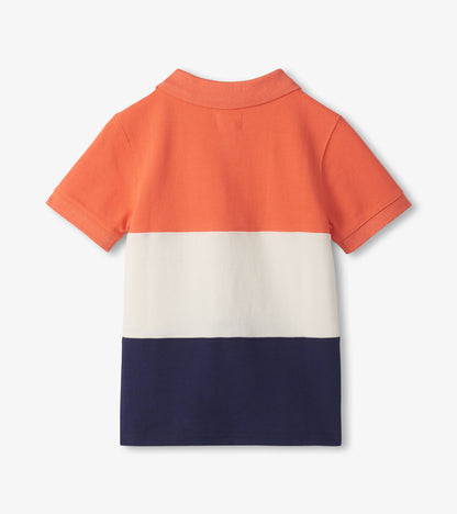 Back view of a boys polo shirt with orange, white, and navy color blocks and short sleeves