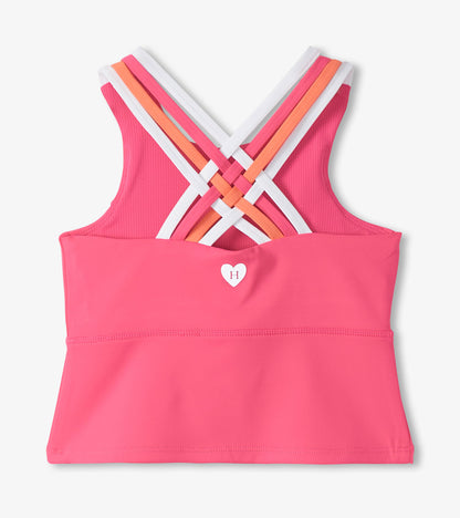 Pink girls active tank top with multicolor crisscross straps and small heart logo, front view