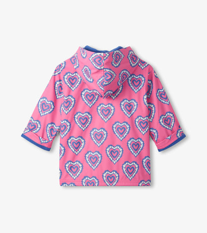 Pink hooded girls raincoat with blue heart print and blue trim, back view