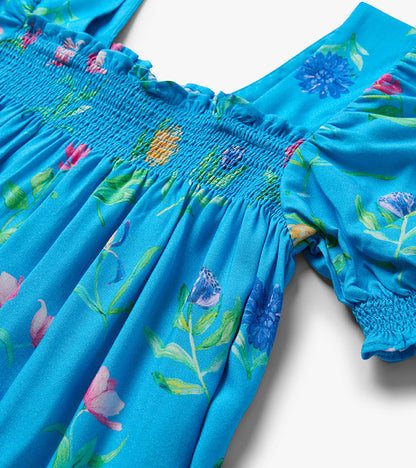 Blue floral girls dress with smocked waist, puff sleeves, and gathered skirt detail
