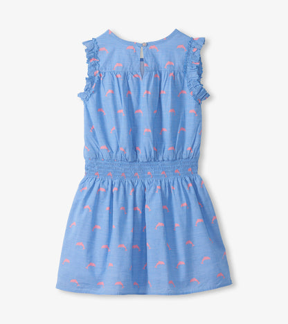 Back view of girls blue dress with pink dolphin print, ruffled cap sleeves, and keyhole opening
