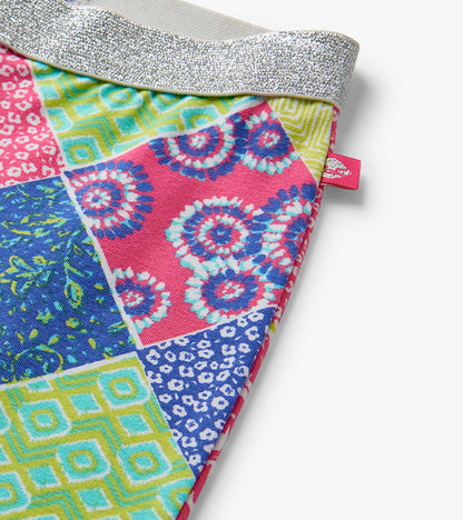 Colorful patchwork girls bell-bottom pants with silver glitter waistband, close-up detail