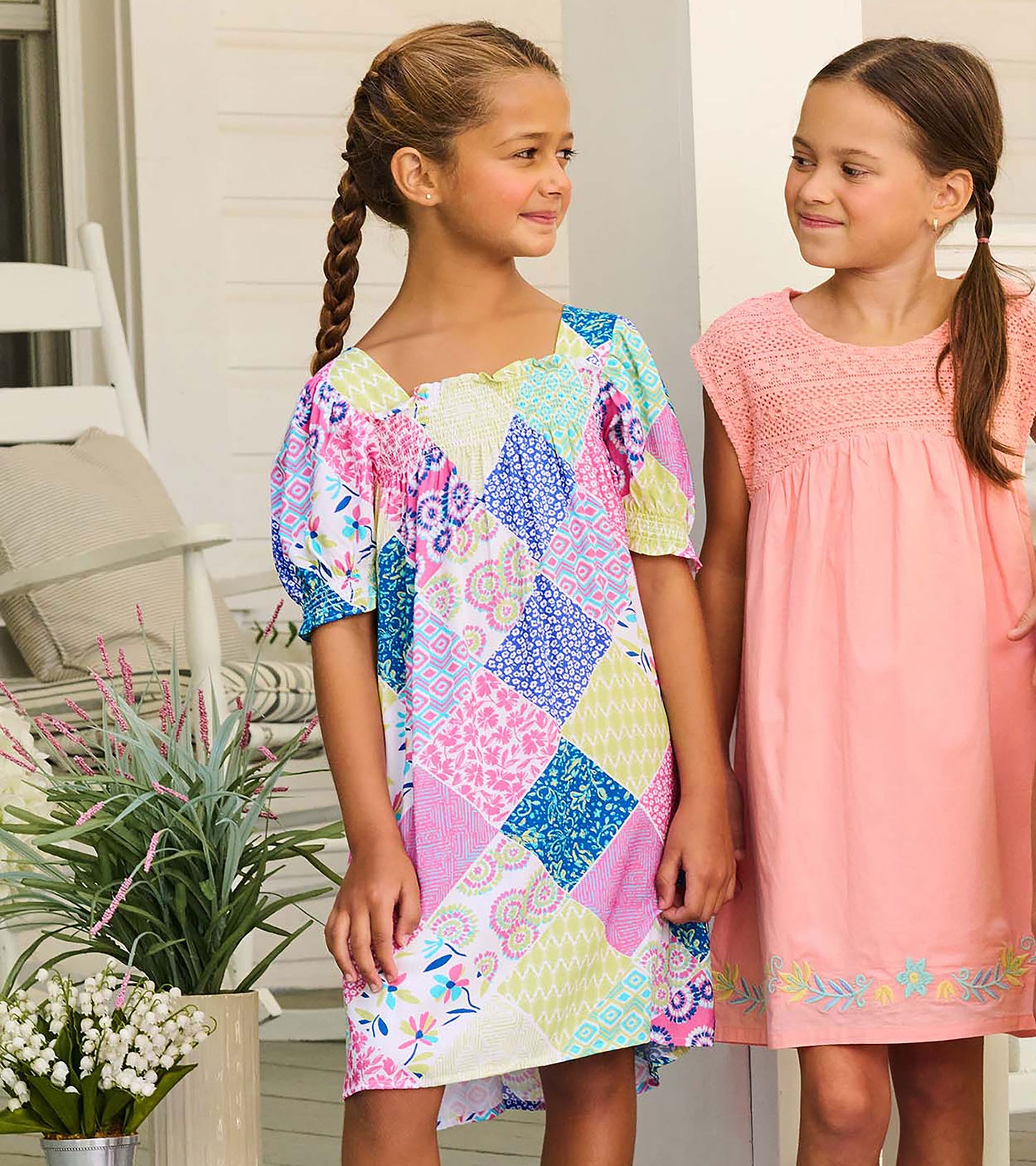 Girls patchwork smocked dress with puff sleeves and square neckline, shown on model from the front