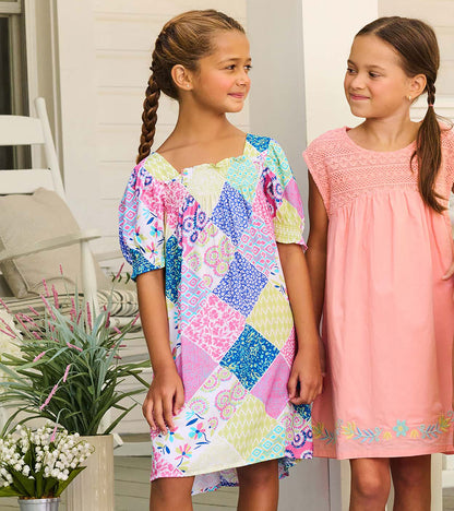 Girls patchwork smocked dress with puff sleeves and square neckline, shown on model from the front