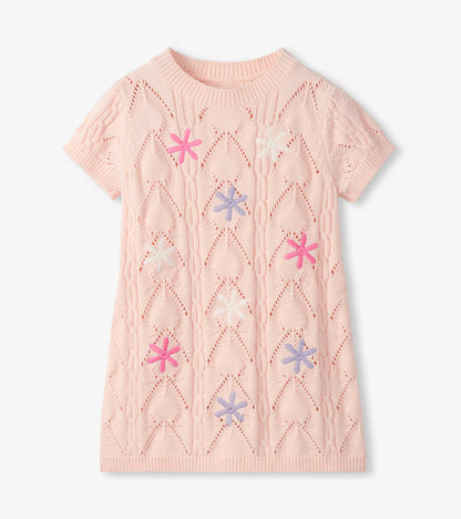 Light pink short-sleeve crochet knit dress with floral cutout pattern and colorful flower appliqués, front view