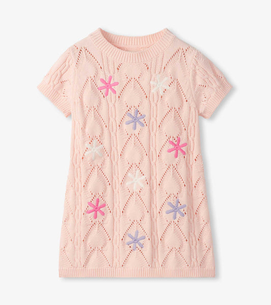 Light pink short-sleeve crochet knit dress with floral cutout pattern and colorful flower appliqués, front view