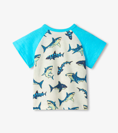 Front view of a boys' raglan T-shirt with turquoise sleeves and cream shark print body, short sleeves.