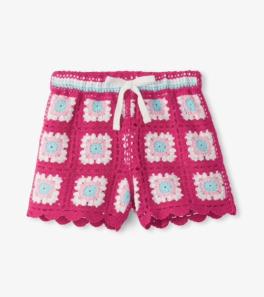 Girls pink crochet shorts with floral square pattern, white drawstring, and scalloped hem, front view