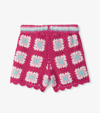 Pink crochet shorts with white, light blue, and pale pink floral pattern and scalloped hem, front view