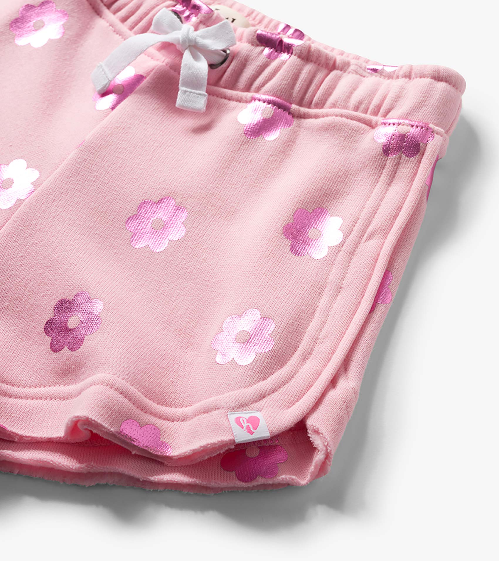 Pink girls pull-on shorts with white drawstring and pink floral print, close-up view