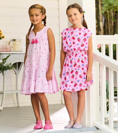 Girls pink sleeveless summer dress with strawberry print and smocked waist, front view on child model