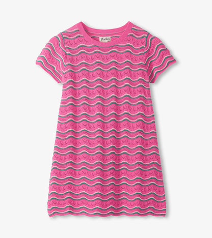 Pink short-sleeve knit dress with white and teal wavy stripes and pointelle pattern on a gray background