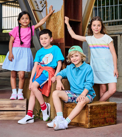 Girls pink mixed-fabric dress with short sleeves and a light blue striped skirt, shown on a child outdoors.